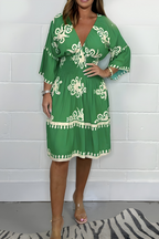 Women's boho dress in green with a flowing skirt, styled for casual and smart-casual outfits.