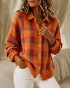 Women's knitted cardigan in orange with check pattern, styled for casual and smart-casual outfits.