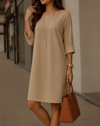 Women's midi dress in khaki with a flowing skirt, styled for casual and smart-casual outfits.