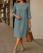 Women's midi dress in peacock blue with a flowing skirt, styled for casual and smart-casual wear.