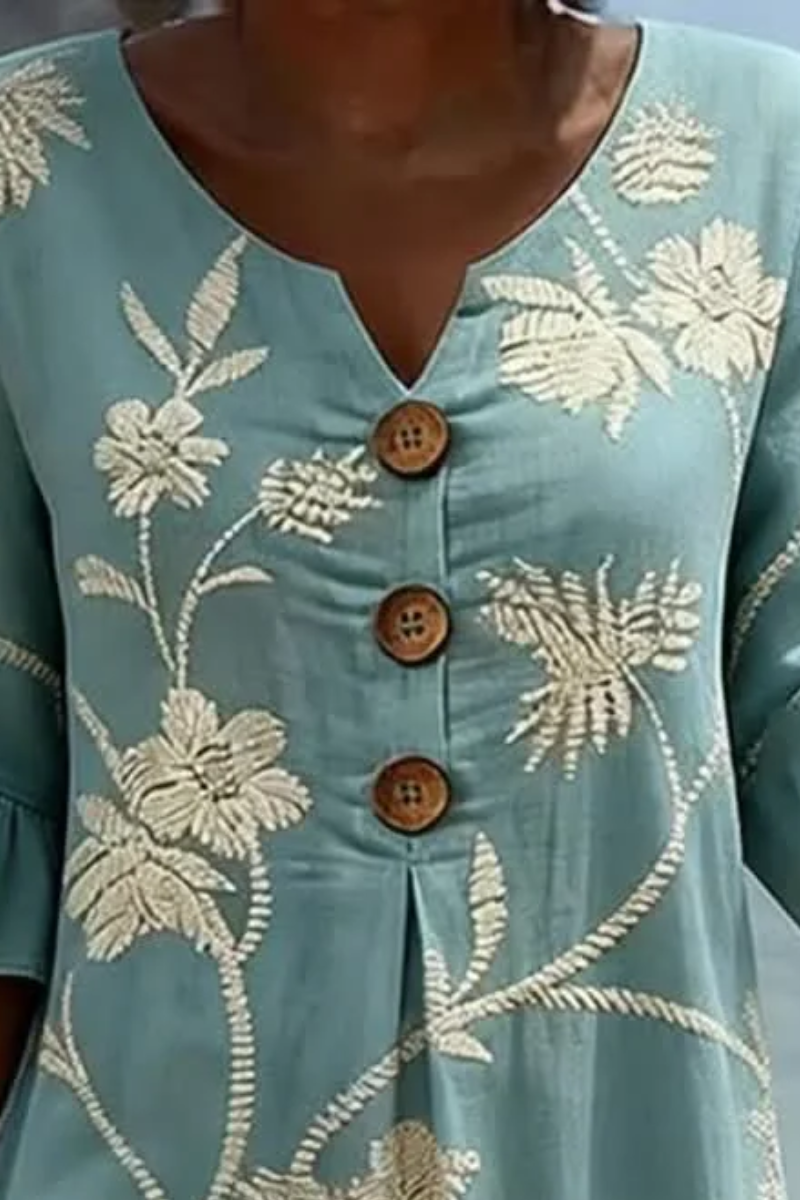 Women's midi dress in light blue with floral print, styled for casual and smart-casual outfits.