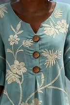 Women's midi dress in light blue with floral print, styled for casual and smart-casual outfits.