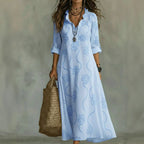 Women's floral summer dress in sky blue with roll-up sleeves, styled for casual and smart-casual outfits.