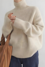 Women’s roll-neck jumper in beige with high knitted collar, styled for casual and smart-casual outfits.