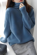 Women’s roll-neck jumper in blue with high knitted collar, styled for casual and smart-casual outfits.