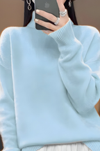 Women’s roll-neck jumper in light blue with high knitted collar, styled for casual and smart-casual outfits.