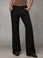 Women's loose fit trousers in black with a high waistband, styled for casual and smart-casual outfits.