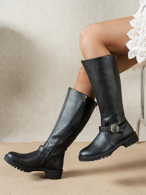 Women's ankle boots in black with a wide toe box, styled for casual and smart-casual outfits.