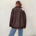 Women's oversized leather jacket in brown with dropped shoulders, styled for casual and smart-casual outfits.