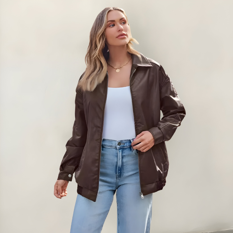 Women's oversized leather jacket in brown with dropped shoulders, styled for casual and smart-casual outfits.