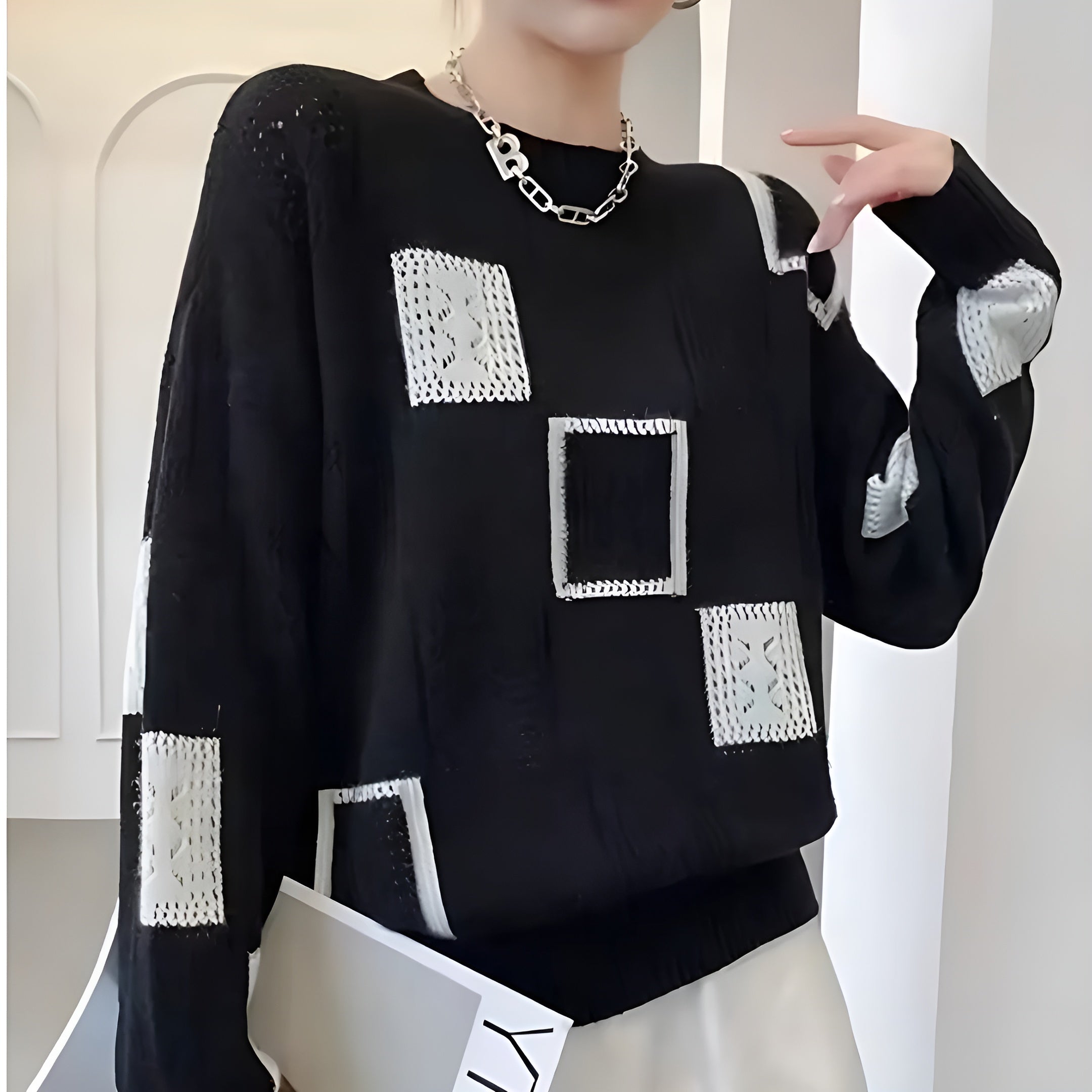 Women's patchwork jumper in black with panelled design, styled for casual and smart-casual outfits.