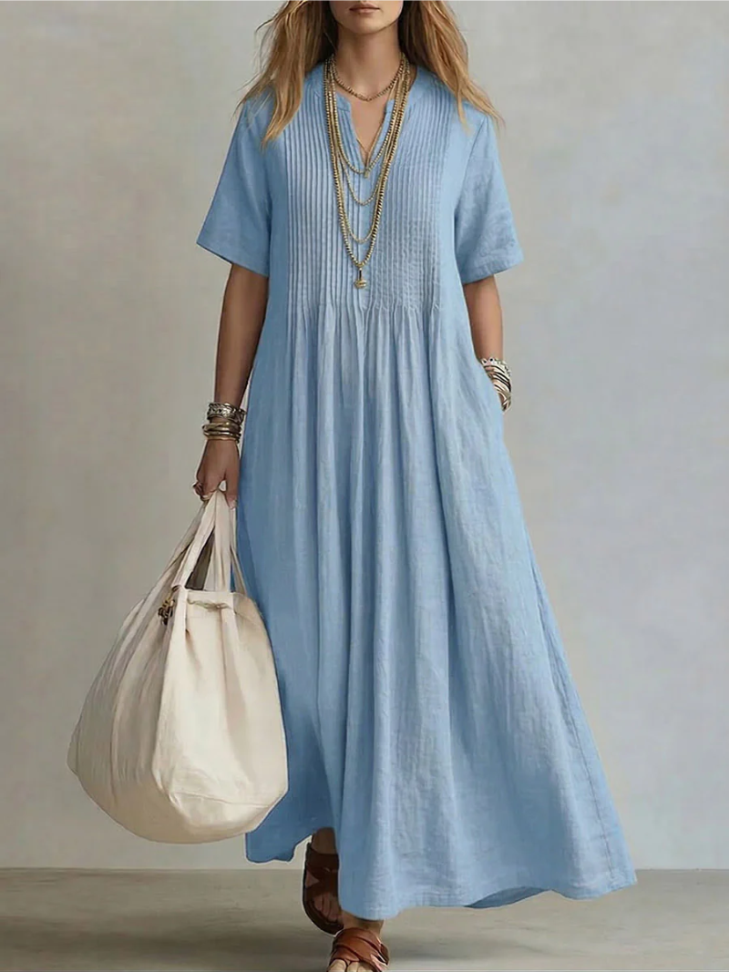 Women's pleated dress in blue with a flowing pleated skirt, styled for casual and smart-casual outfits.