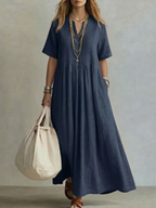 Women's pleated dress in navy with a flowing pleated skirt, styled for casual and smart-casual outfits.