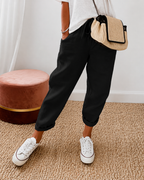 Women's relaxed fit trousers in black with elasticated waist, styled for casual and smart-casual outfits.