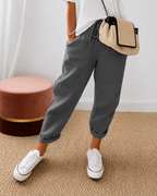 Women's relaxed fit trousers in dark grey with elasticated waist, styled for casual and smart-casual outfits.