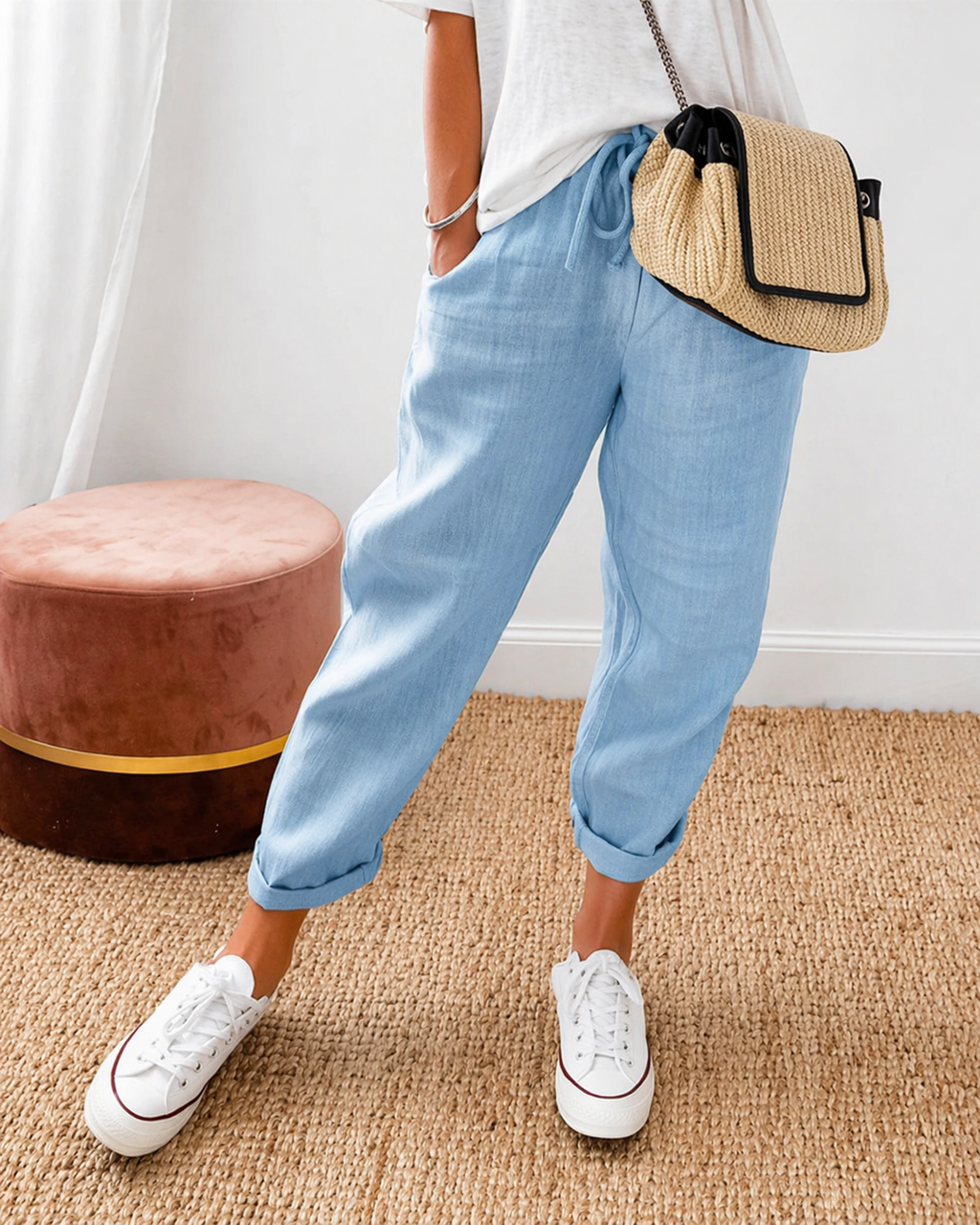Women's relaxed fit trousers in light blue with elasticated waist, styled for casual and smart-casual outfits.