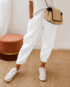 Women's relaxed fit trousers in white with elasticated waist, styled for casual and smart-casual outfits.