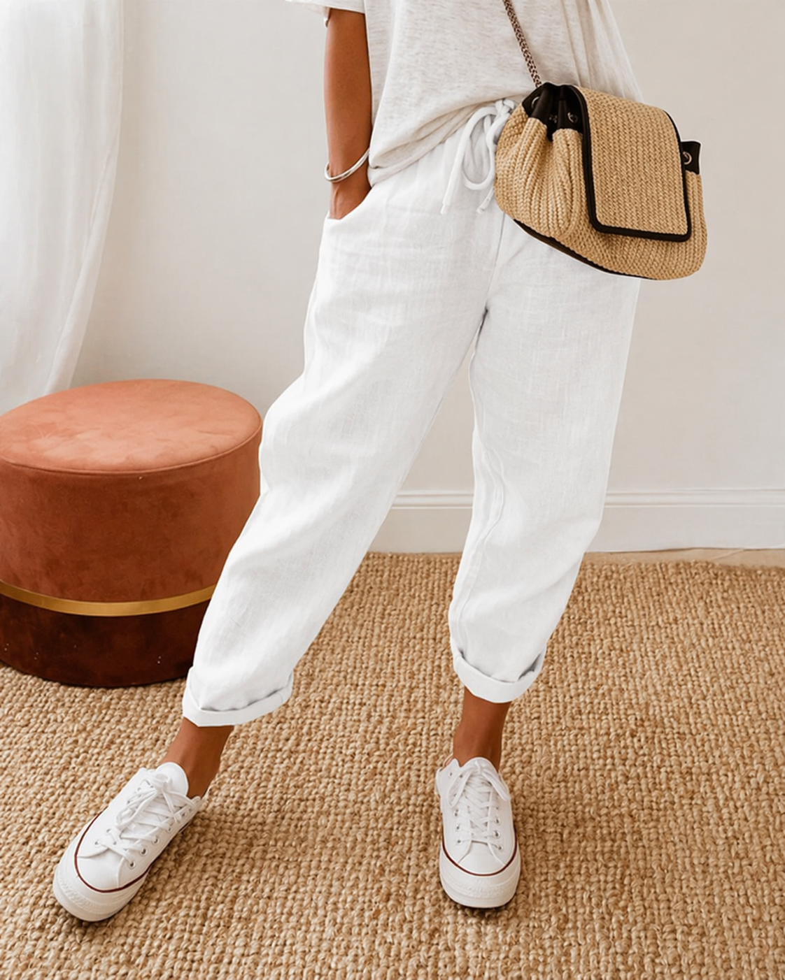 Women's relaxed fit trousers in white with elasticated waist, styled for casual and smart-casual outfits.