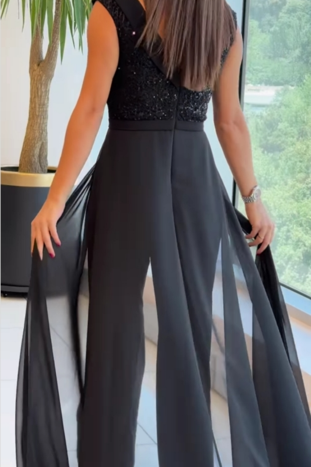 Women's sleeveless jumpsuit in black with a structured fit, styled for casual and smart-casual outfits.
