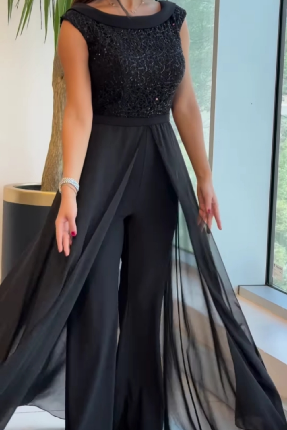 Women's sleeveless jumpsuit in black with a structured fit, styled for casual and smart-casual outfits.
