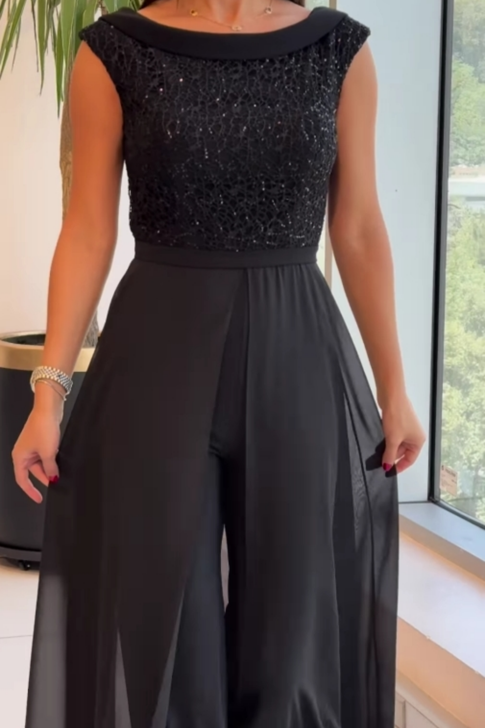 Women's sleeveless jumpsuit in black with a structured fit, styled for casual and smart-casual outfits.