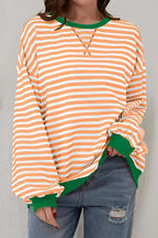 Women's sweatshirt in orange with striped pattern, styled for casual and smart-casual outfits.