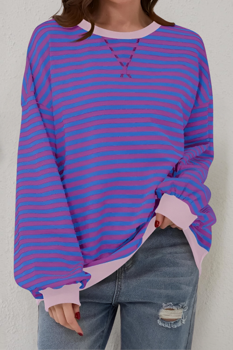 Women's sweatshirt in pink and blue with striped pattern, styled for casual and smart-casual outfits.