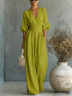 Women's jumpsuit in light green with deep V-neck, styled for casual and smart-casual outfits.