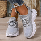 Women's trainers in grey with lace-up knitted upper, styled for casual and smart-casual outfits.