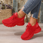 Women's trainers in red with lace-up knitted upper, styled for casual and smart-casual outfits.